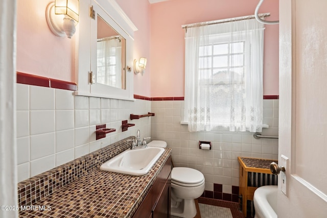 228 Albert Pl, Elberon, NJ 07740 - bathroom featuring toilet, vanity, tile walls, a wainscoted wall, and tile patterned floors