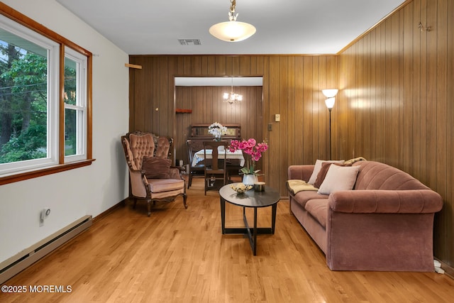 9 Riccis Dr, Jackson, NJ 08527 - living room with a baseboard heating unit, a chandelier, plenty of natural light, light wood-style flooring, and wood walls