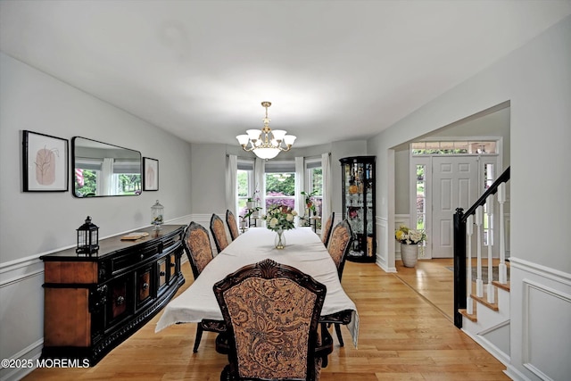 2 Hampton Hollow Dr, Perrineville, NJ 08535 - dining area featuring a chandelier, stairs, light wood-style floors, a wainscoted wall, and a decorative wall