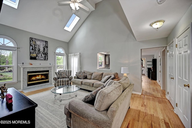 2 Hampton Hollow Dr, Perrineville, NJ 08535 - living room featuring a skylight, a fireplace, high vaulted ceiling, light wood-type flooring, and a ceiling fan