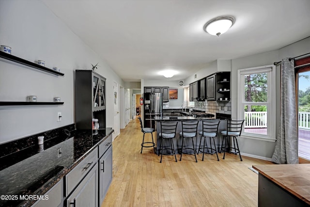 2 Hampton Hollow Dr, Perrineville, NJ 08535 - kitchen featuring open shelves, a kitchen breakfast bar, light wood finished floors, a peninsula, and dark stone countertops