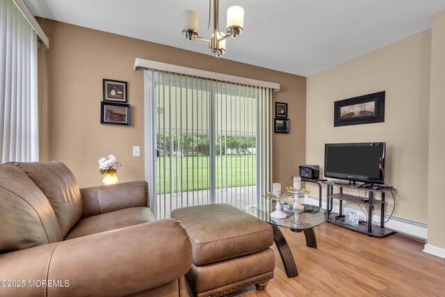 87 Prince Charles Dr, Toms River, NJ 08757 - living room with a baseboard radiator, light wood-style flooring, a chandelier, and baseboards