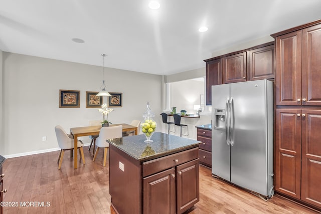 52 Pate Dr, Middletown, NJ 07748 - kitchen with stainless steel refrigerator with ice dispenser, a kitchen island, light wood-style flooring, dark stone countertops, and hanging light fixtures