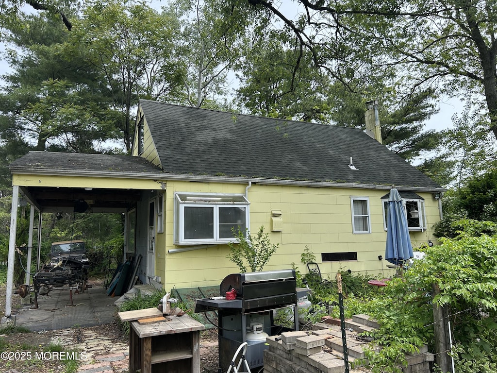 1211 Cedar Bridge Ave, Brick, NJ 08723 - back of house featuring a shingled roof, a patio, and a chimney