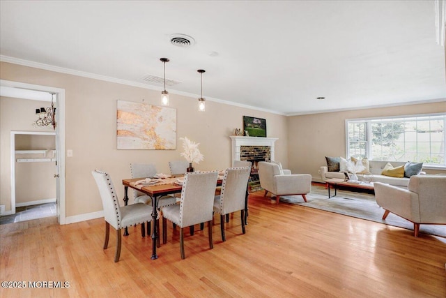 635 Susan Ln, Brielle, NJ 08730 - dining space with light wood finished floors, crown molding, a fireplace, and baseboards