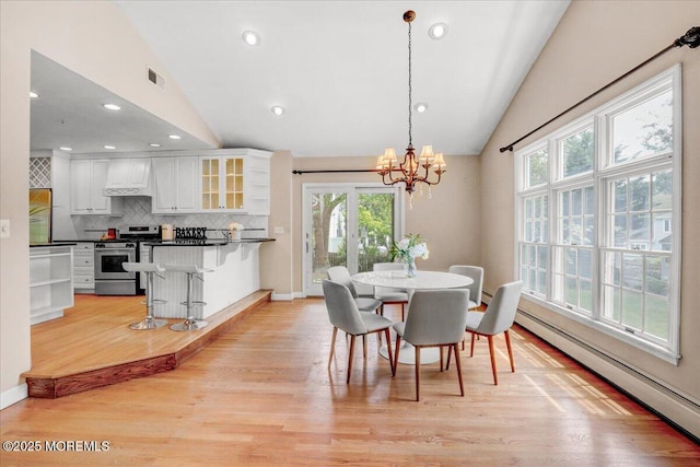 635 Susan Ln, Brielle, NJ 08730 - dining space featuring vaulted ceiling, a baseboard heating unit, plenty of natural light, a chandelier, and light wood-style flooring
