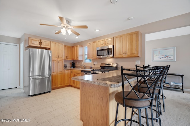 13 Lake Superior Dr, Little Egg Harbor, NJ 08087 - kitchen featuring stainless steel appliances, light brown cabinets, a peninsula, a breakfast bar, and a ceiling fan