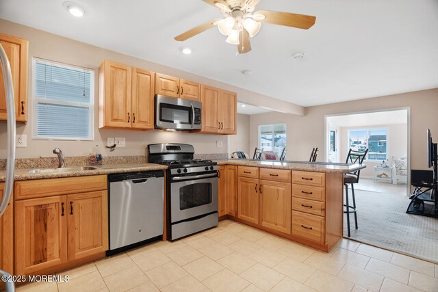 13 Lake Superior Dr, Little Egg Harbor, NJ 08087 - kitchen with appliances with stainless steel finishes, a sink, a peninsula, light brown cabinetry, and a kitchen breakfast bar