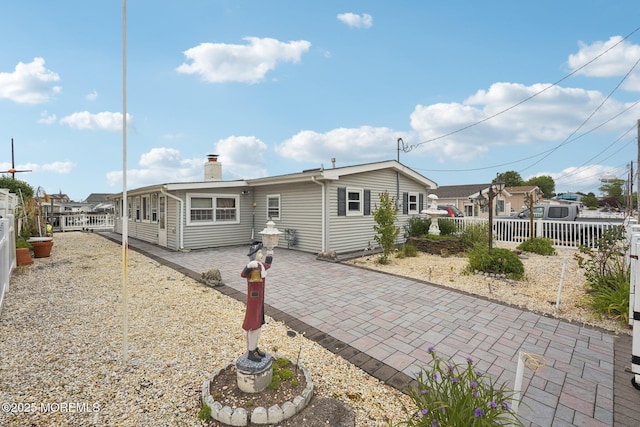 927 Beach Haven W Blvd, Manahawkin, NJ 08050 - view of front of house featuring a fenced backyard, a chimney, and a patio
