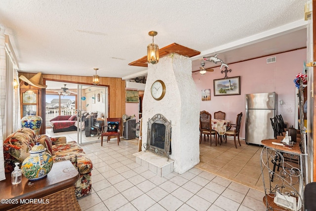 927 Beach Haven W Blvd, Manahawkin, NJ 08050 - living room featuring ceiling fan, light tile patterned floors, a fireplace, a textured ceiling, and wooden walls