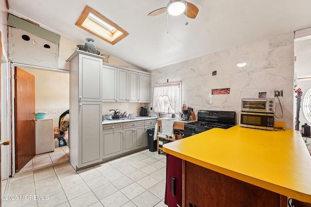 927 Beach Haven W Blvd, Manahawkin, NJ 08050 - kitchen featuring a ceiling fan, tile walls, gray cabinets, lofted ceiling, and a skylight