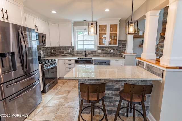 540 Vaughn Ave, Forked River, NJ 08731 - kitchen featuring appliances with stainless steel finishes, a sink, ornate columns, a breakfast bar area, and light stone countertops