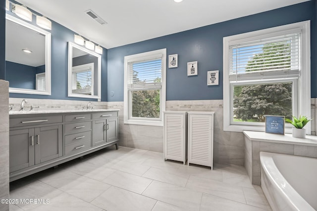 41 Revere Pl, Freehold, NJ 07728 - bathroom with tile walls, double vanity, a garden tub, and wainscoting