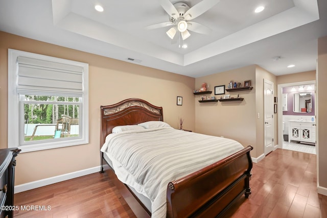 41 Revere Pl, Freehold, NJ 07728 - bedroom with a raised ceiling, baseboards, wood finished floors, recessed lighting, and connected bathroom