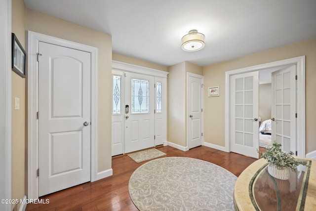 41 Revere Pl, Freehold, NJ 07728 - foyer entrance with french doors, dark wood-style floors, and baseboards