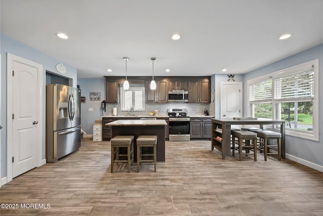 41 Revere Pl, Freehold, NJ 07728 - kitchen with appliances with stainless steel finishes, a sink, recessed lighting, a kitchen island, and tasteful backsplash