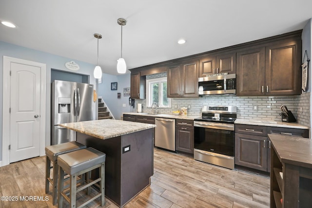 41 Revere Pl, Freehold, NJ 07728 - kitchen featuring appliances with stainless steel finishes, a sink, dark brown cabinets, light wood finished floors, and recessed lighting