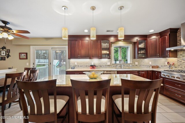41 Revere Pl, Freehold, NJ 07728 - kitchen featuring stainless steel gas cooktop, dark brown cabinets, tasteful backsplash, and hanging light fixtures