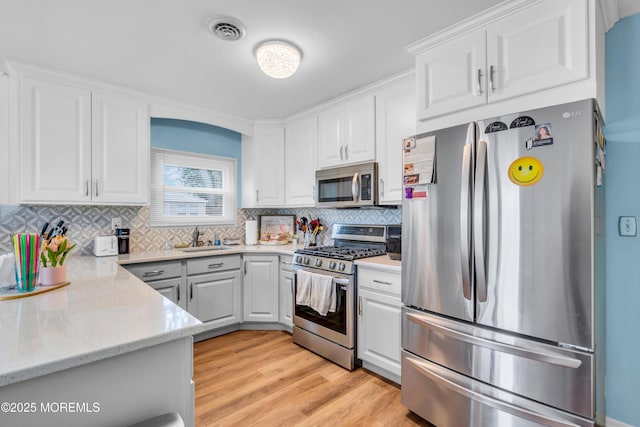 81 Encinitas Dr, Toms River, NJ 08757 - kitchen with appliances with stainless steel finishes, white cabinets, backsplash, light wood-style flooring, and a sink