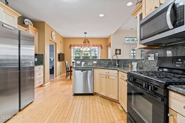 67 Isabella Dr, Manchester, NJ 08759 - kitchen with appliances with stainless steel finishes, light brown cabinetry, a sink, a chandelier, and a peninsula