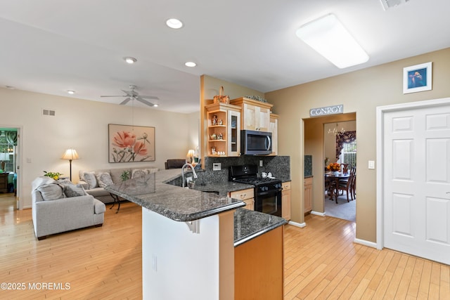 67 Isabella Dr, Manchester, NJ 08759 - kitchen featuring black range with gas cooktop, stainless steel microwave, a peninsula, a sink, and light wood-style floors