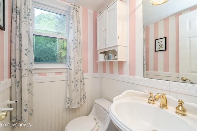 36 Merion Dr, Manalapan, NJ 07726 - bathroom with wallpapered walls, a sink, a wainscoted wall, and toilet