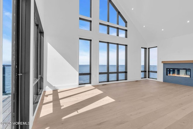 2 Brant Dr Lot 5.01, Atlantic Highlands, NJ 07716 - unfurnished living room with a water view, high vaulted ceiling, a glass covered fireplace, and wood finished floors