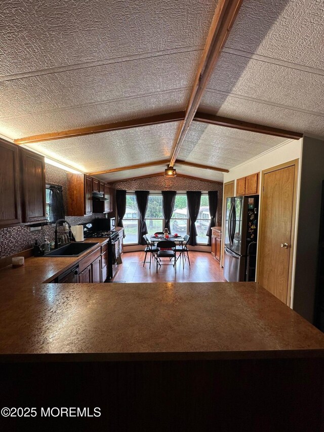 138 Oak Dr, Manchester, NJ 08759 - kitchen featuring freestanding refrigerator, range with gas stovetop, lofted ceiling, a sink, and light wood-type flooring