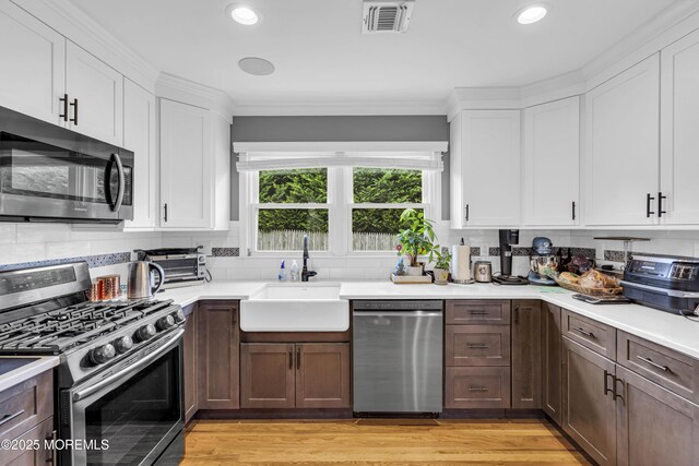 18 Delaware Ave, West Long Branch, NJ 07764 - kitchen featuring appliances with stainless steel finishes, light countertops, white cabinets, recessed lighting, and light wood finished floors