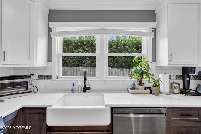 18 Delaware Ave, West Long Branch, NJ 07764 - kitchen with stainless steel dishwasher, ornamental molding, decorative backsplash, light countertops, and white cabinetry