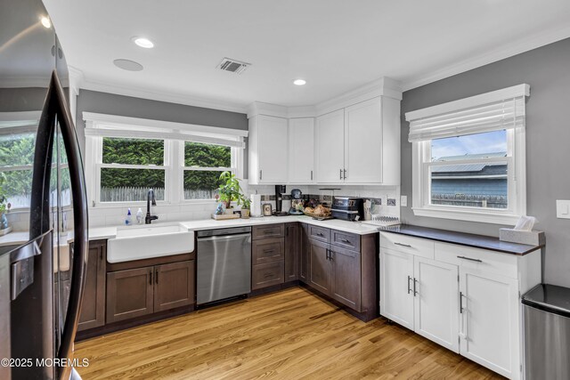 18 Delaware Ave, West Long Branch, NJ 07764 - kitchen with appliances with stainless steel finishes, backsplash, white cabinets, ornamental molding, and light wood finished floors