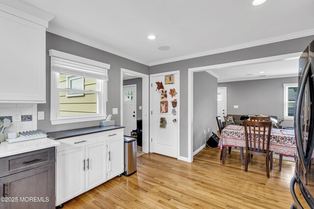 18 Delaware Ave, West Long Branch, NJ 07764 - kitchen with light wood-type flooring, ornamental molding, plenty of natural light, white cabinets, and recessed lighting