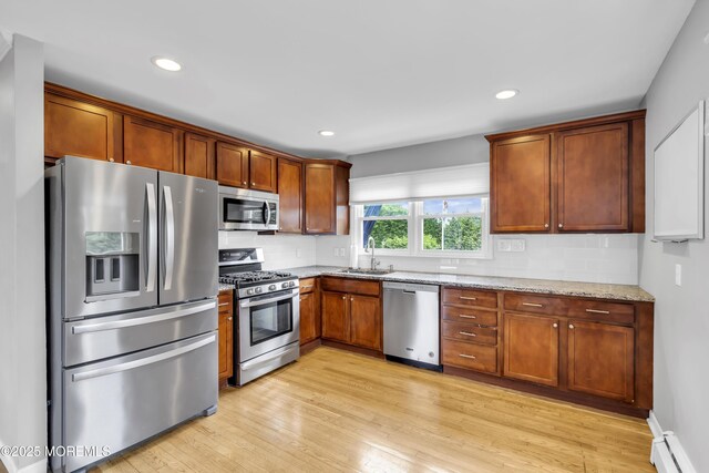 20 Delaware Ave, West Long Branch, NJ 07764 - kitchen featuring stainless steel appliances, a baseboard radiator, light stone counters, light wood-style floors, and recessed lighting