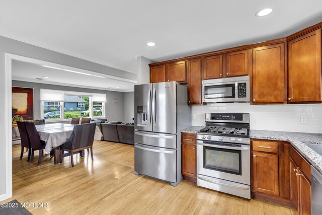 20 Delaware Ave, West Long Branch, NJ 07764 - kitchen featuring stainless steel appliances, open floor plan, light stone counters, light wood-type flooring, and backsplash