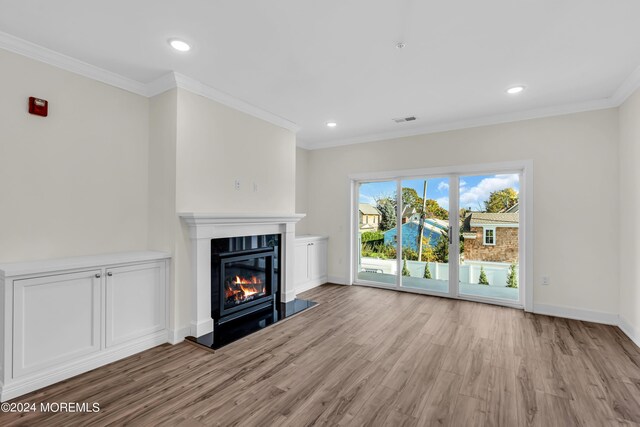34 Broad St Unit 306, Manasquan, NJ 08736 - unfurnished living room with wood finished floors, a glass covered fireplace, crown molding, baseboards, and recessed lighting