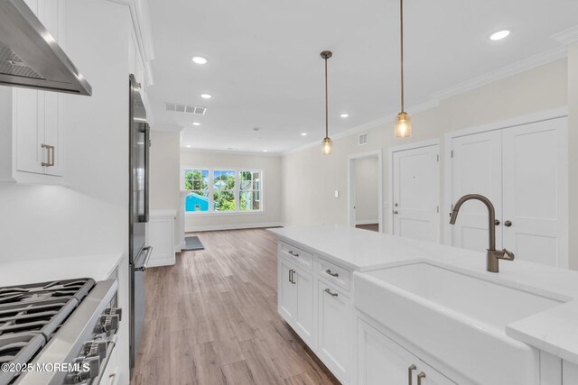 34 Broad St Unit 306, Manasquan, NJ 08736 - kitchen with extractor fan, a sink, ornamental molding, light wood finished floors, and white cabinetry