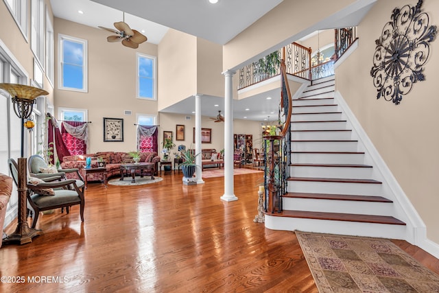 13 Cedar Tree Ln, Toms River, NJ 08753 - entrance foyer featuring decorative columns, ceiling fan, a towering ceiling, wood finished floors, and stairs