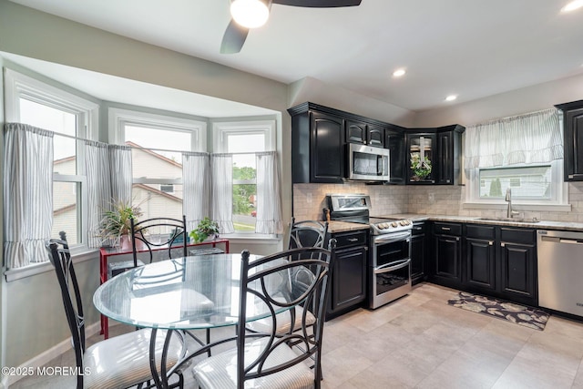 20 Sugarbush Rd, Howell, NJ 07731 - kitchen with appliances with stainless steel finishes, dark cabinets, a sink, ceiling fan, and backsplash