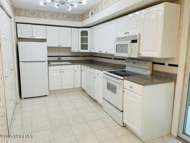 8 Indiana Ct Unit 1016, Matawan, NJ 07747 - kitchen with white appliances, dark countertops, white cabinetry, a chandelier, and a sink