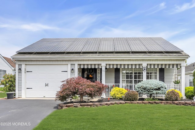 28 Mansfield Ave, Manchester, NJ 08759 - view of front of home with a porch, an attached garage, roof mounted solar panels, a front yard, and driveway