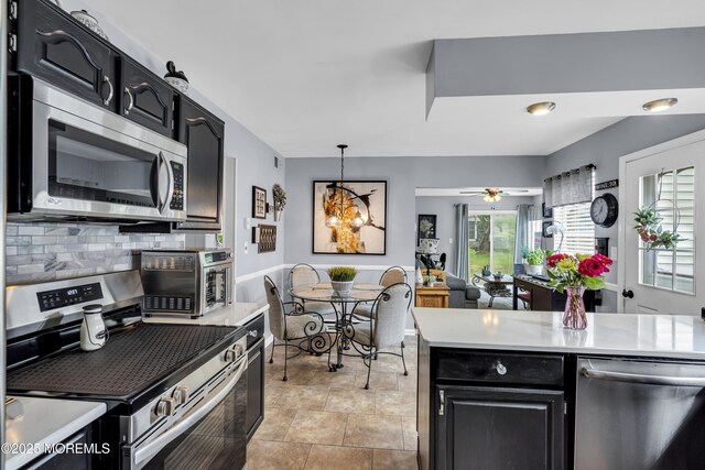 28 Mansfield Ave, Manchester, NJ 08759 - kitchen with stainless steel appliances, tasteful backsplash, light countertops, dark cabinetry, and hanging light fixtures