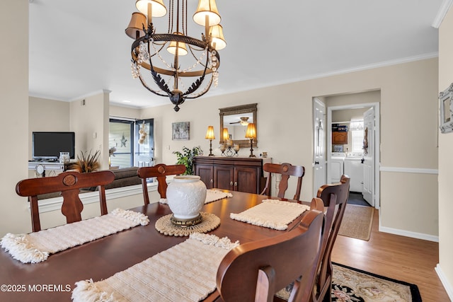 28 Mansfield Ave, Manchester, NJ 08759 - dining room with washer and dryer, wood finished floors, a chandelier, baseboards, and ornamental molding