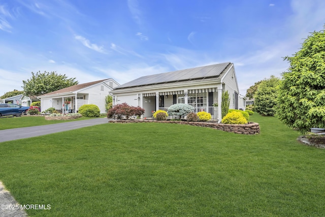 28 Mansfield Ave, Manchester, NJ 08759 - view of front of house featuring covered porch, a front yard, asphalt driveway, a garage, and solar panels