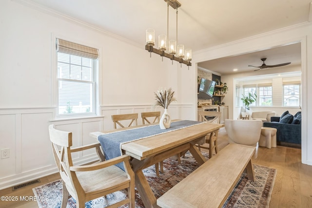 8 W St, Rumson, NJ 07760 - dining room with ornamental molding, a decorative wall, a wainscoted wall, light wood-style flooring, and ceiling fan