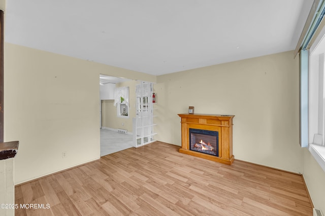 443 Shady Ln, Howell, NJ 07731 - unfurnished living room with light wood-style flooring and a glass covered fireplace