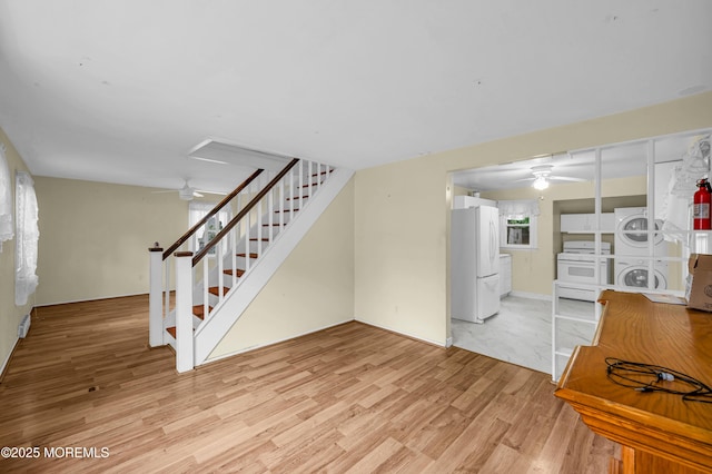 443 Shady Ln, Howell, NJ 07731 - unfurnished living room featuring ceiling fan, stacked washing machine and dryer, stairway, and light wood-type flooring