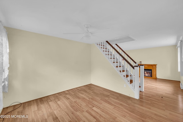 443 Shady Ln, Howell, NJ 07731 - unfurnished living room featuring light wood-style floors, ceiling fan, a glass covered fireplace, and stairs