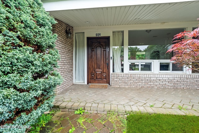 606 Deal Rd, Oakhurst, NJ 07755 - doorway to property with brick siding and covered porch