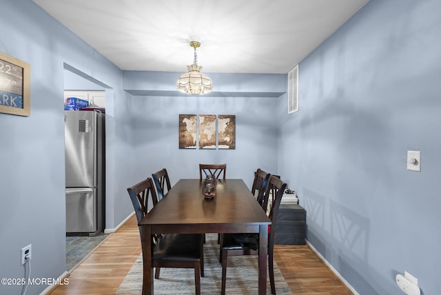 516 Wellington Pl, Aberdeen, NJ 07747 - dining room featuring a chandelier, wood finished floors, and baseboards