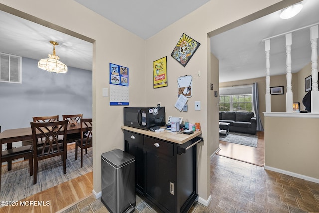 516 Wellington Pl, Aberdeen, NJ 07747 - kitchen with black microwave, dark cabinetry, baseboards, a chandelier, and stone finish flooring